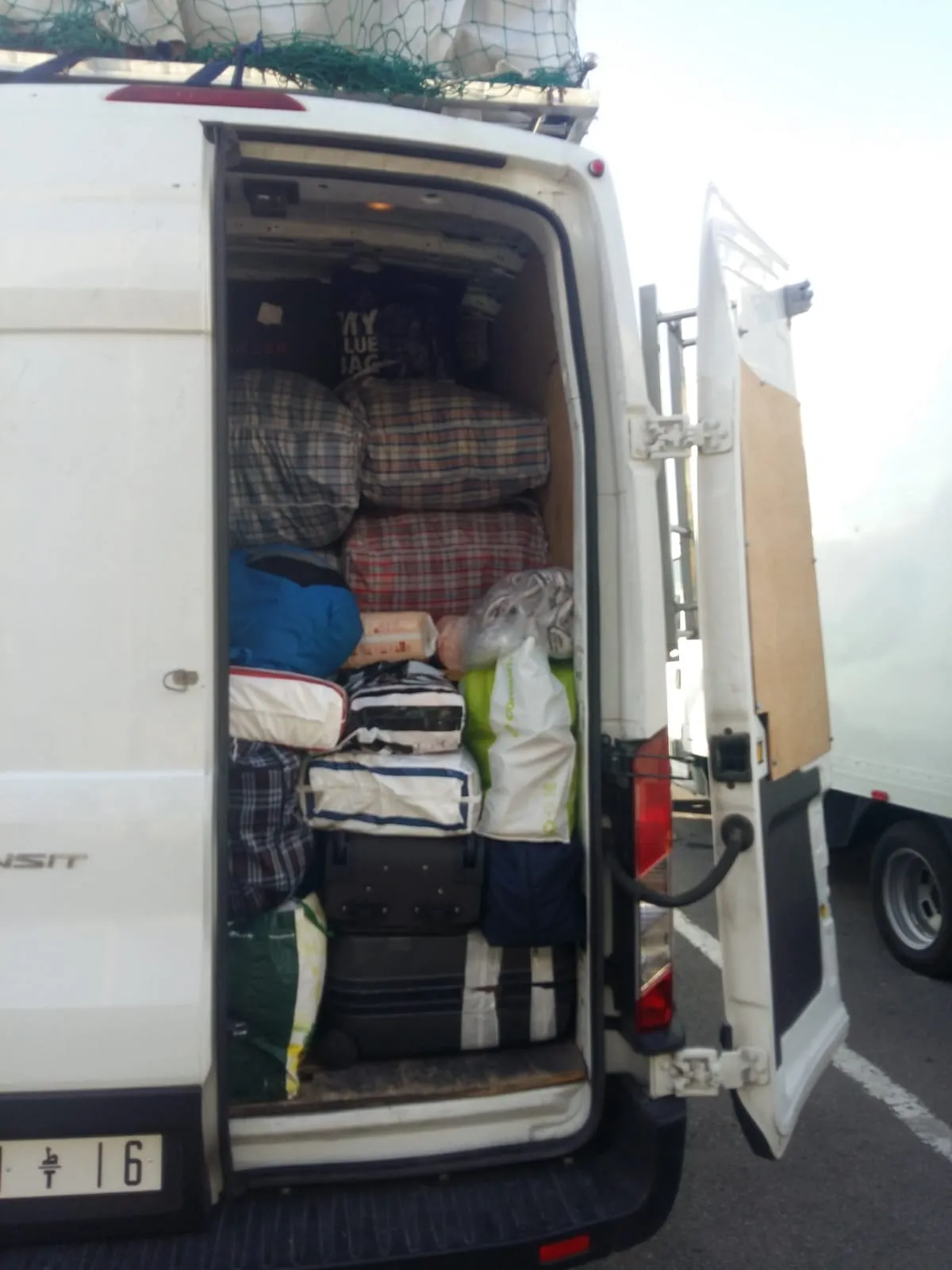 Parte trasera del furgón cargada de bultos y equipaje